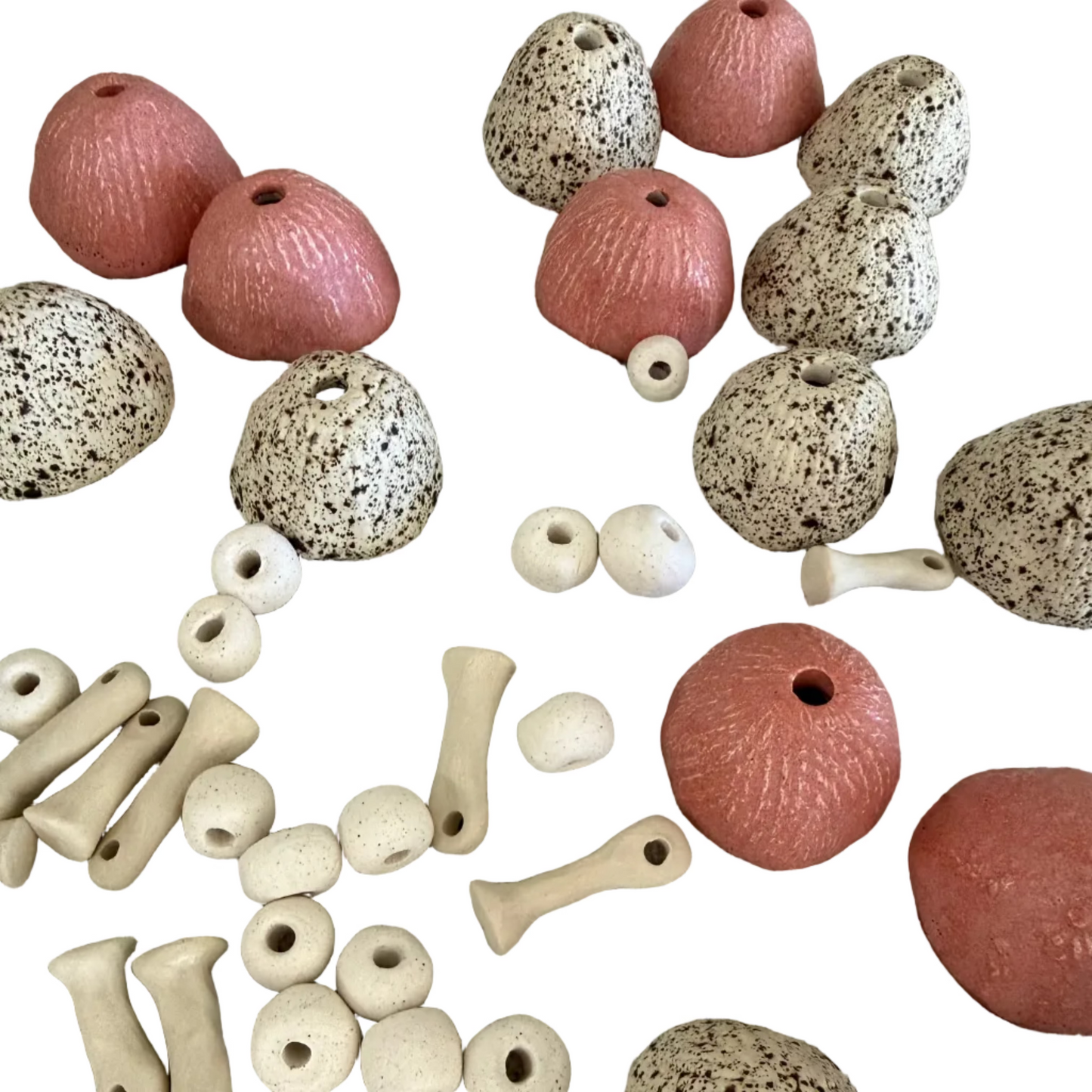 Collection of pottery toadstool beads and parts on a white background