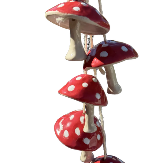 Decorative hanging toadstools with red caps and white spots on a white background
