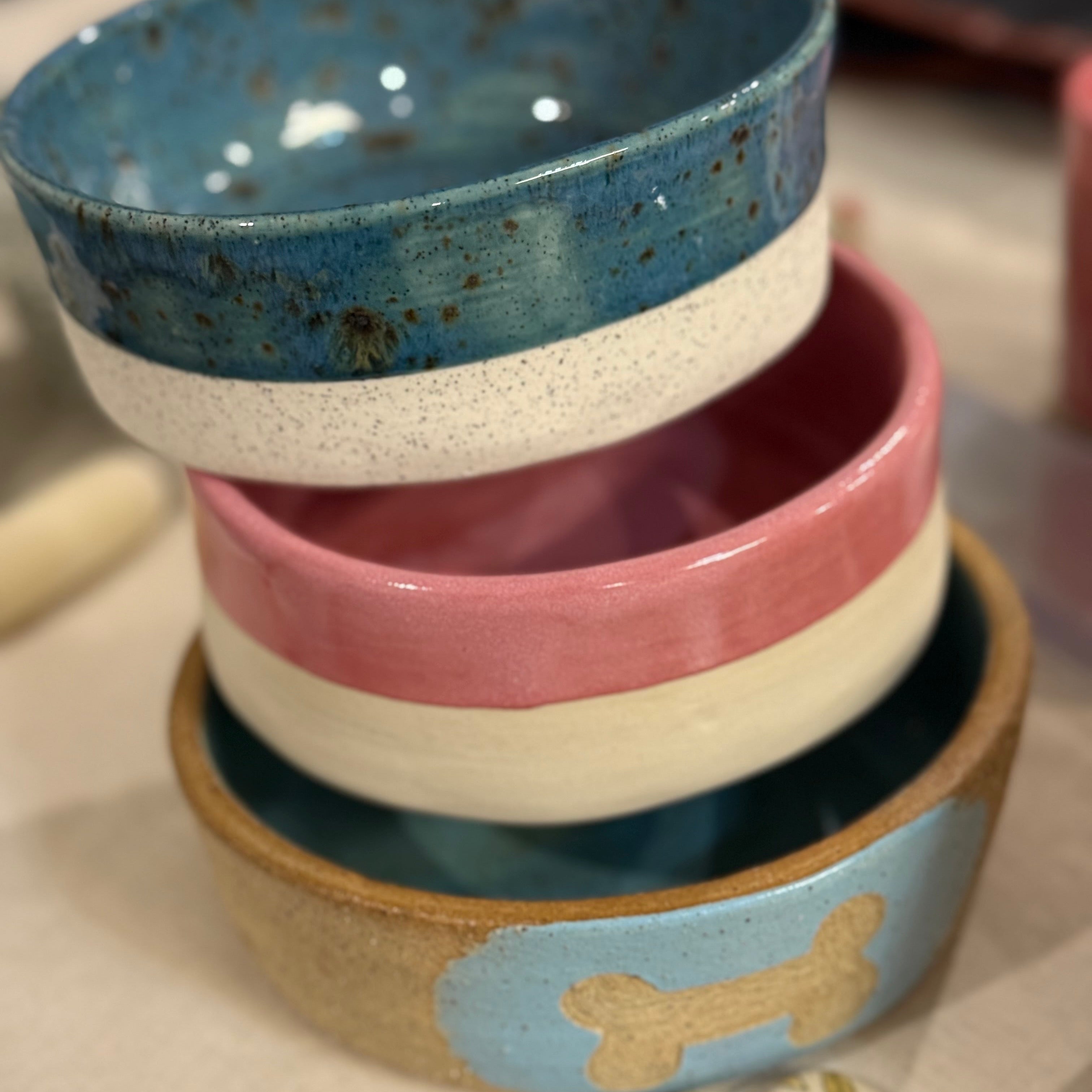 Stack of ceramic bowls with different colors and designs on a surface.