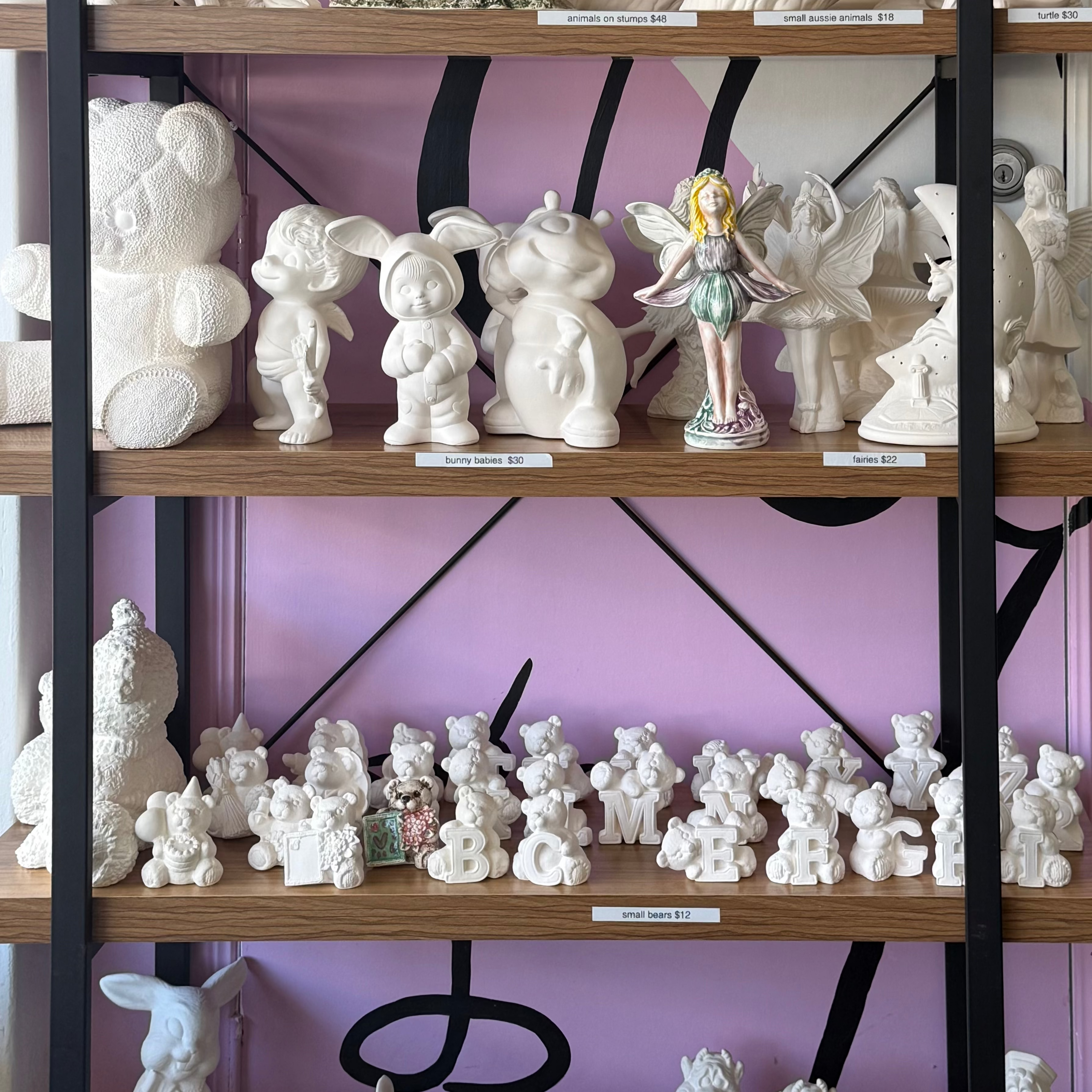 Shelves with various ceramic figurines against a purple wall