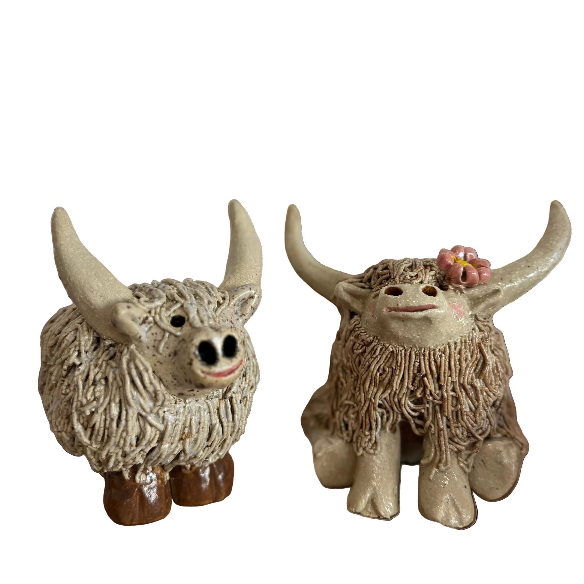 Two ceramic highland cow  figurines with a white background

